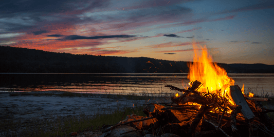 Man packing grooming kit for work/school—end of summer reset. Campfire by the water. Sunset image.