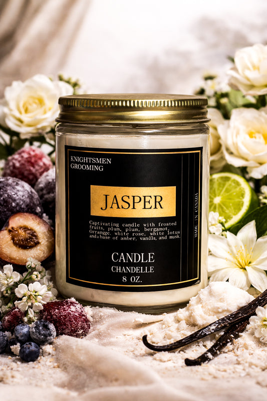 Candle jar labeled 'Jasper' surrounded by flowers and fruits on a soft background