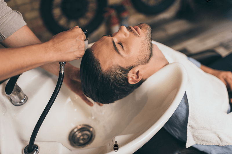 Step‑by‑step hair care routine items—shampoo, conditioner, hair oil. Barber washing hair.
