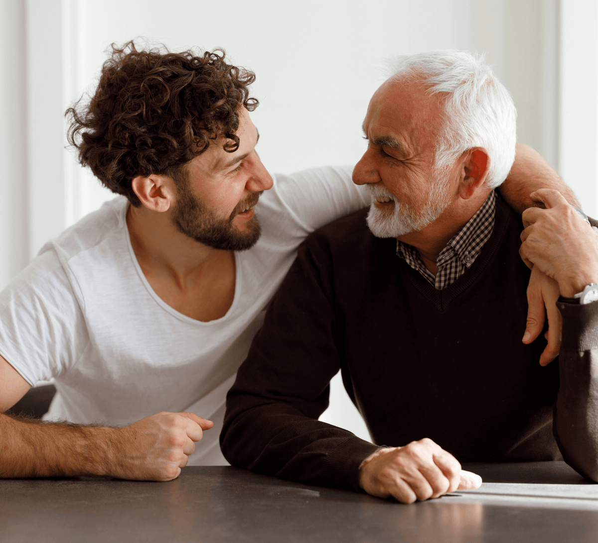 Multiple generations of men (grandfather, father, son) exchanging a grooming gift box.