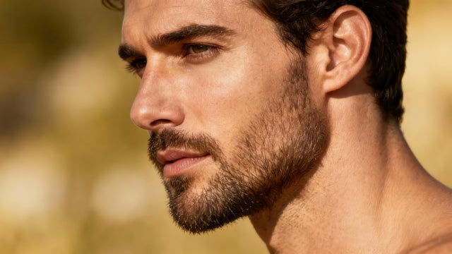 handsome man with short beard using knightsmen grooming beard oil