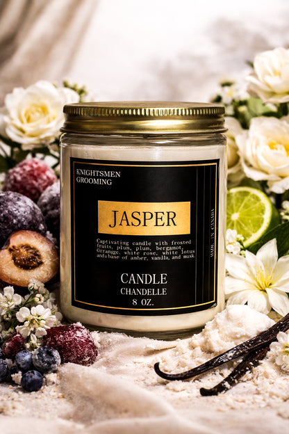 Candle jar labeled 'Jasper' surrounded by flowers and fruits on a soft background